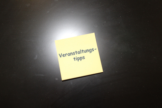 Das Bild zeigt einen gelben Notizzettel auf schwarzem Untergrund. Auf dem Notizzettel steht das Wort "Veranstaltungstipps".